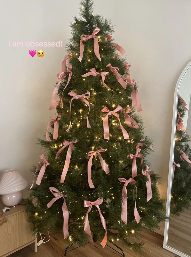 a decorated christmas tree with pink bows