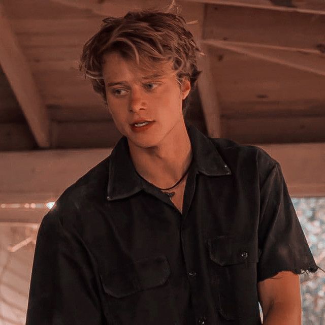 a young man in black shirt holding a remote control