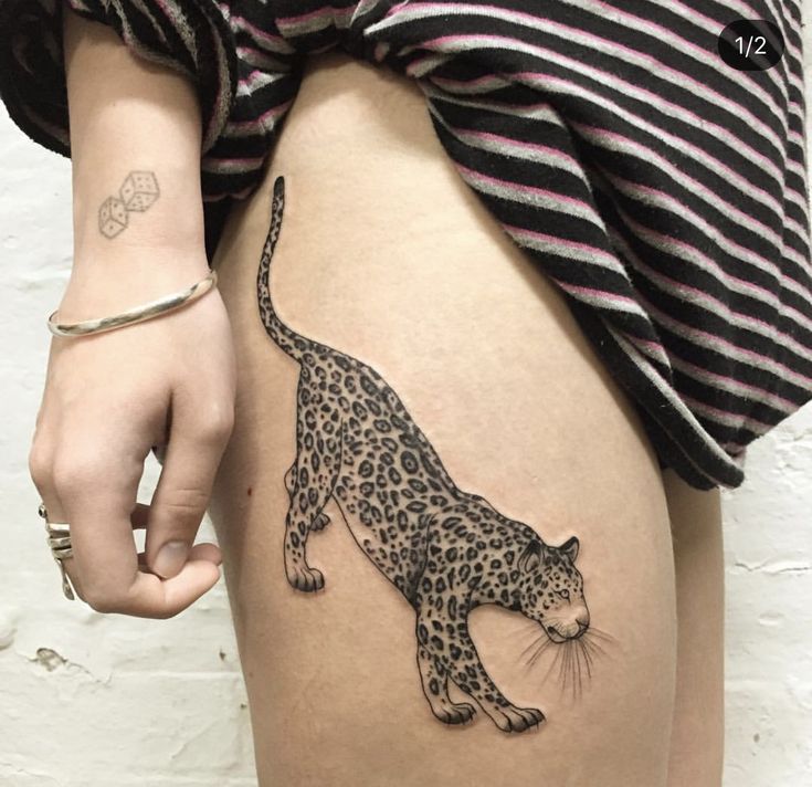 a woman's thigh with a tattoo of a leopard on it