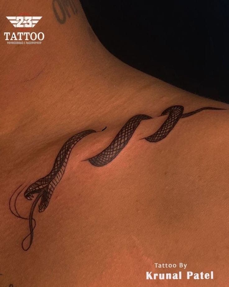 a tattoo on the back of a woman's neck with an intricate snake design