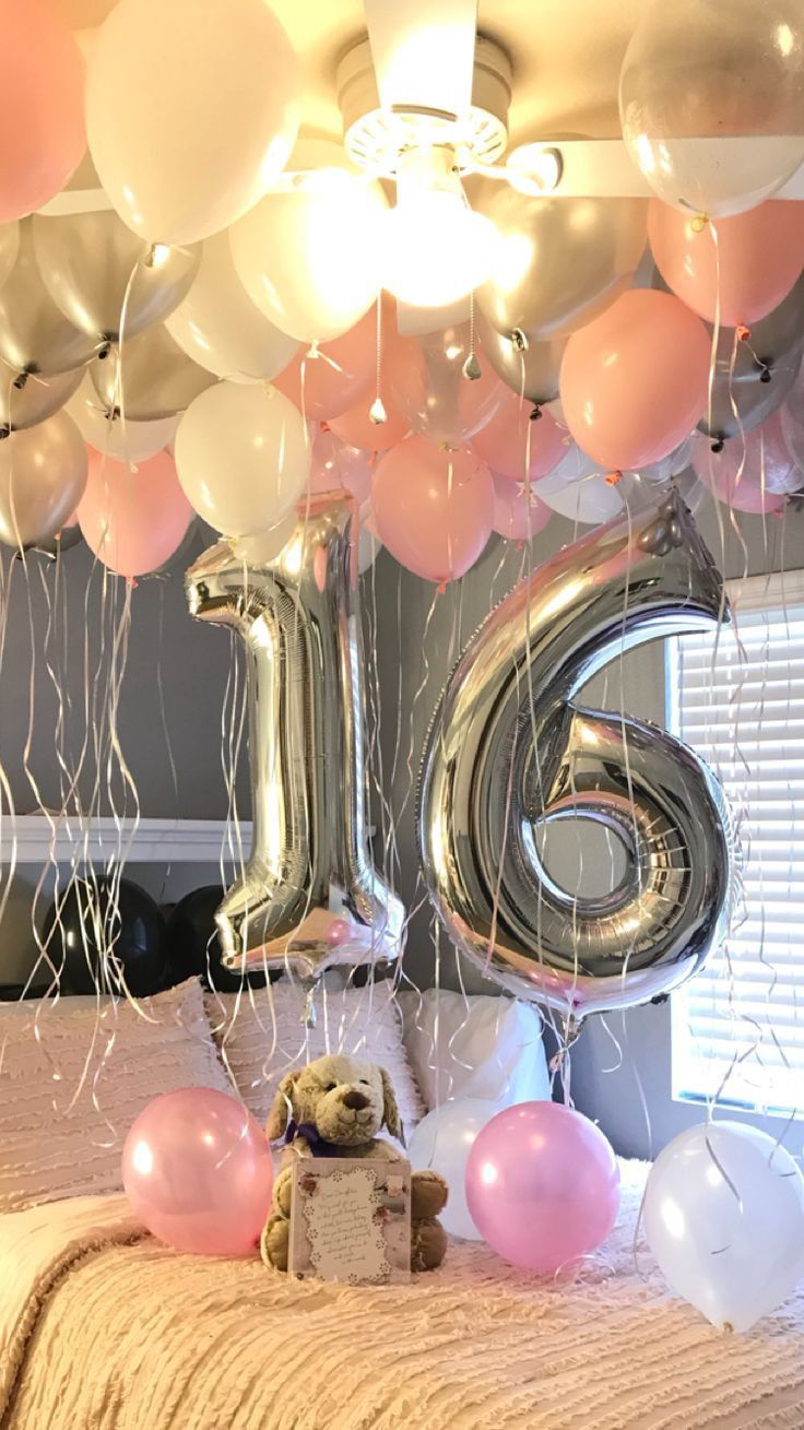 balloons are floating in the air above a bed with a teddy bear and number six on it