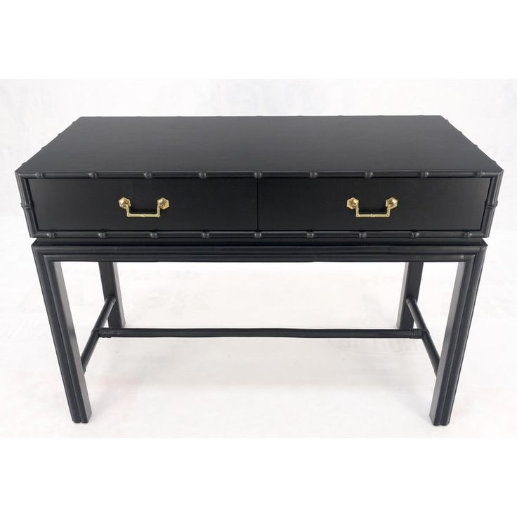 a black desk with two drawers and gold handles on the top, against a white background