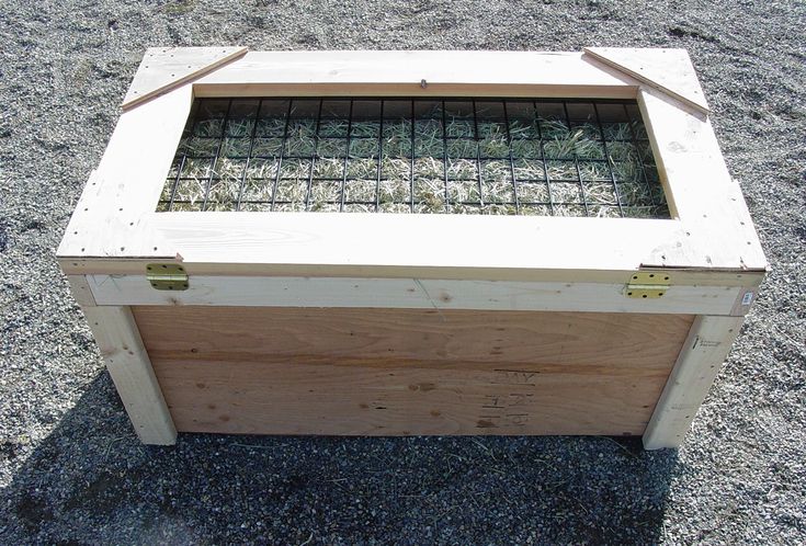 a wooden box with glass in it sitting on gravel