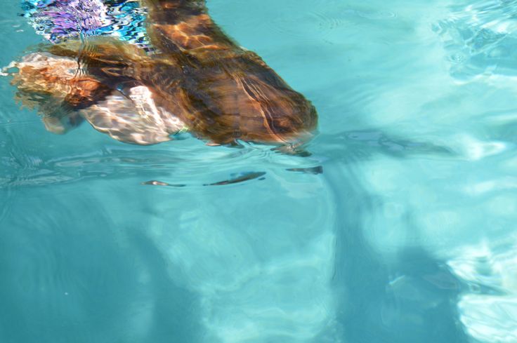 a person swimming in the water with a flower on their head