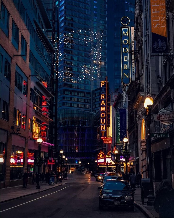 a city street filled with tall buildings at night