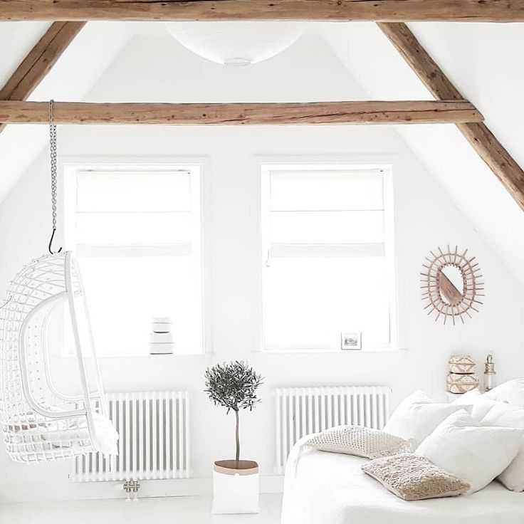 a bedroom with white walls and wooden beams