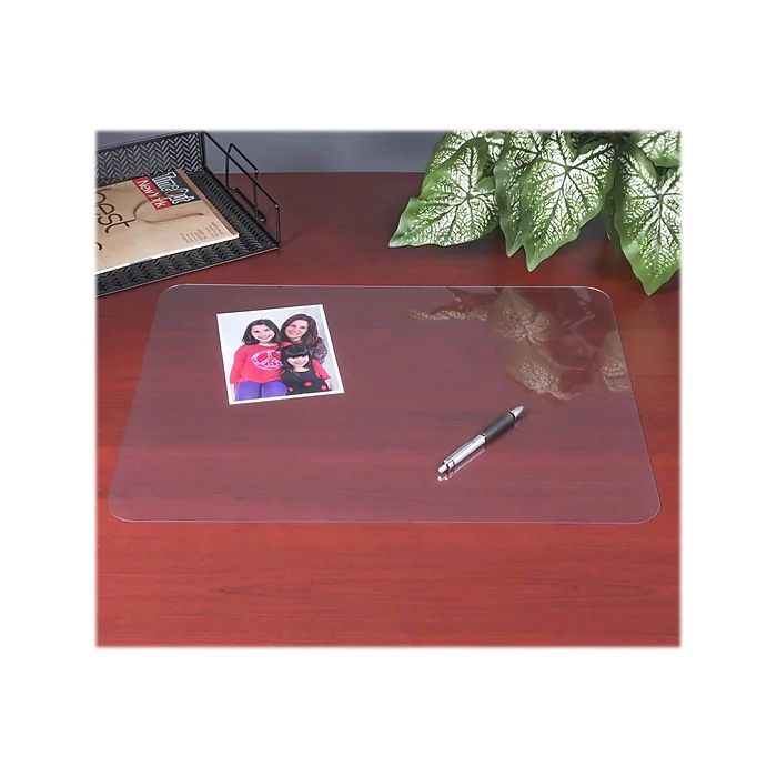 an office desk with a pen and pictures on the glass table top next to a potted plant