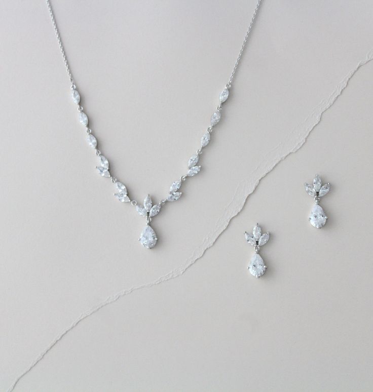 a necklace and earring set on a white surface