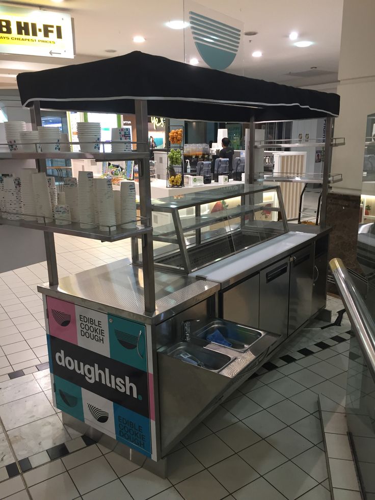 the inside of a doughnut shop with an umbrella over it's counter area