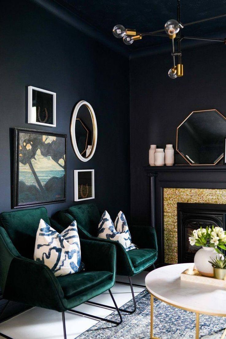 a living room filled with furniture and a fire place under a mirror on the wall