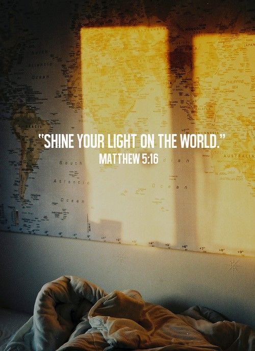 a bed sitting in front of a window with the words shine your light on the world