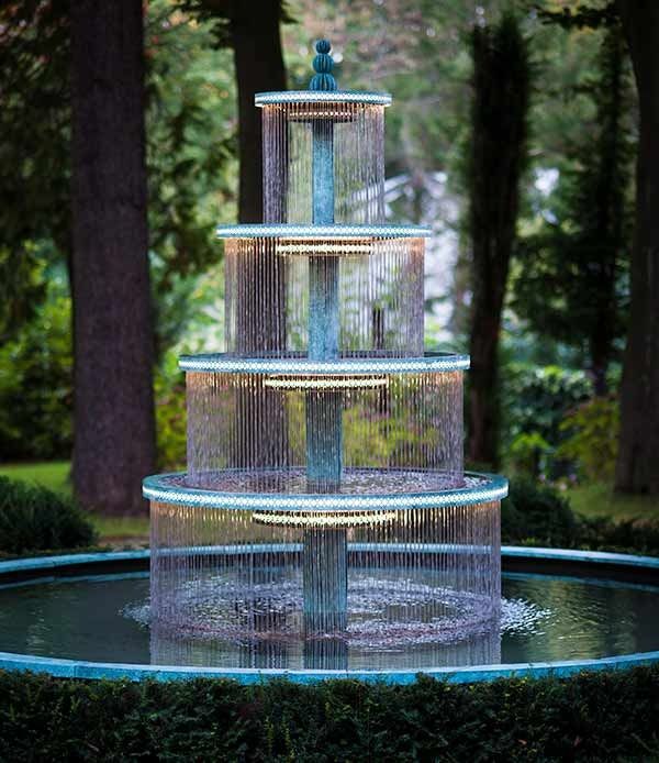 a three tiered fountain in the middle of a park