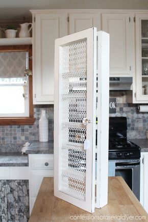 an open cabinet in the middle of a kitchen counter with white cupboards and appliances