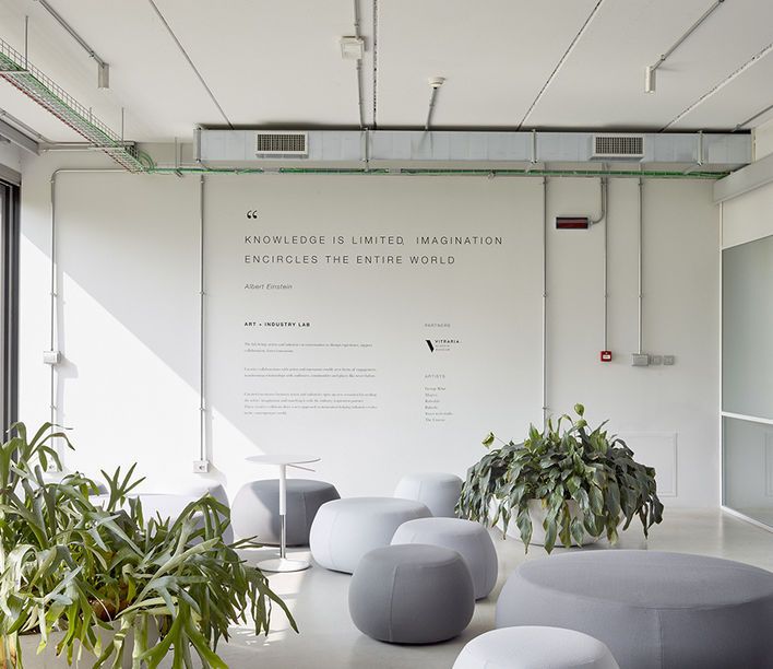 an office with white walls and plants on the floor