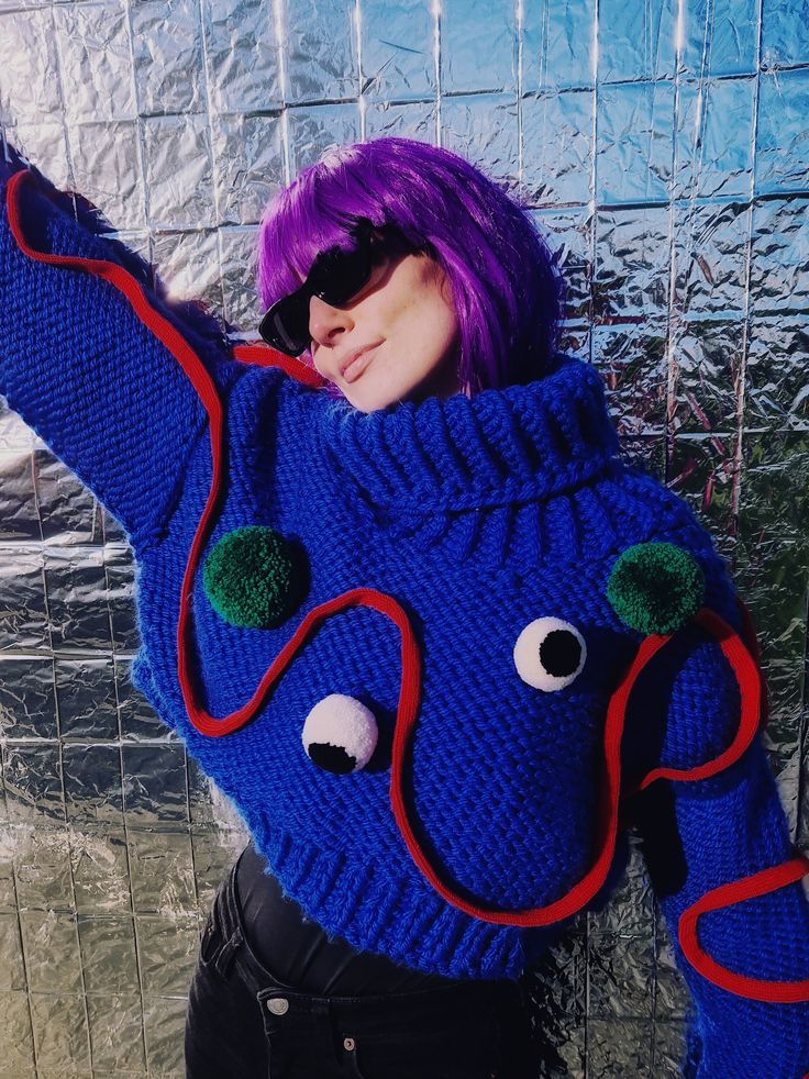 "Introducing the \"Monstrously Chic\" handmade chunky sweater - because who said winter fashion can't be a laugh riot? This blue delight is rocking a rebellious red line pattern, and thanks to two mischievous pom-poms, it's basically a cute monster from a parallel universe. Because who needs ordinary when you can have a sweater that's anything but? Stay cozy, stay quirky!  Please be patient, as this sartorial masterpiece requires two weeks of craftsmanship before it embarks on its journey to your wardrobe. Quality takes time, but rest assured, the wait is worth it for a uniquely tailored touch to your winter style. Sweater comes with 4 pom-poms, 2 in green and 2 eyes." Chunky Knit Blue Knitting Pattern For Fall, Fall Blue Chunky Knit Pattern, Knitted Blue Cropped Sweater For Winter, Blue Knitted Cropped Sweater For Winter, Playful Knitted Winter Sweater, Hand Knitted Blue Sweater For Winter, Blue Winter Knitting Pattern, Blue Knit Fabrication Knitting Pattern For Winter, Playful Blue Knitted Sweater