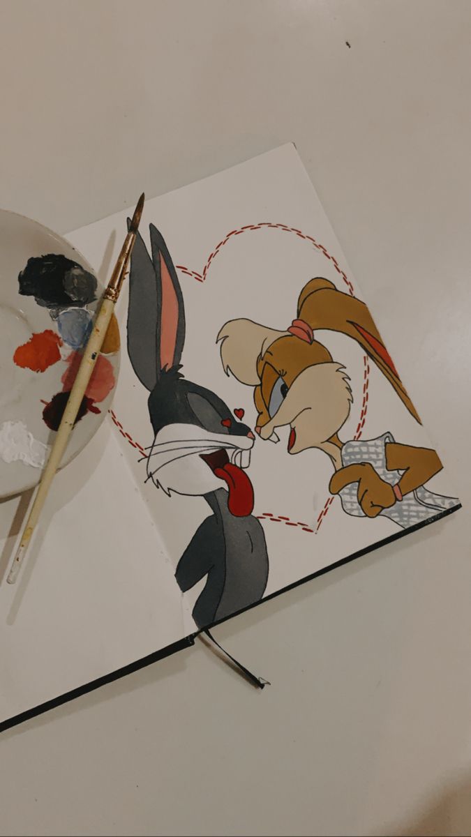 an artist's palette and some paintbrushes on a table with cartoon characters