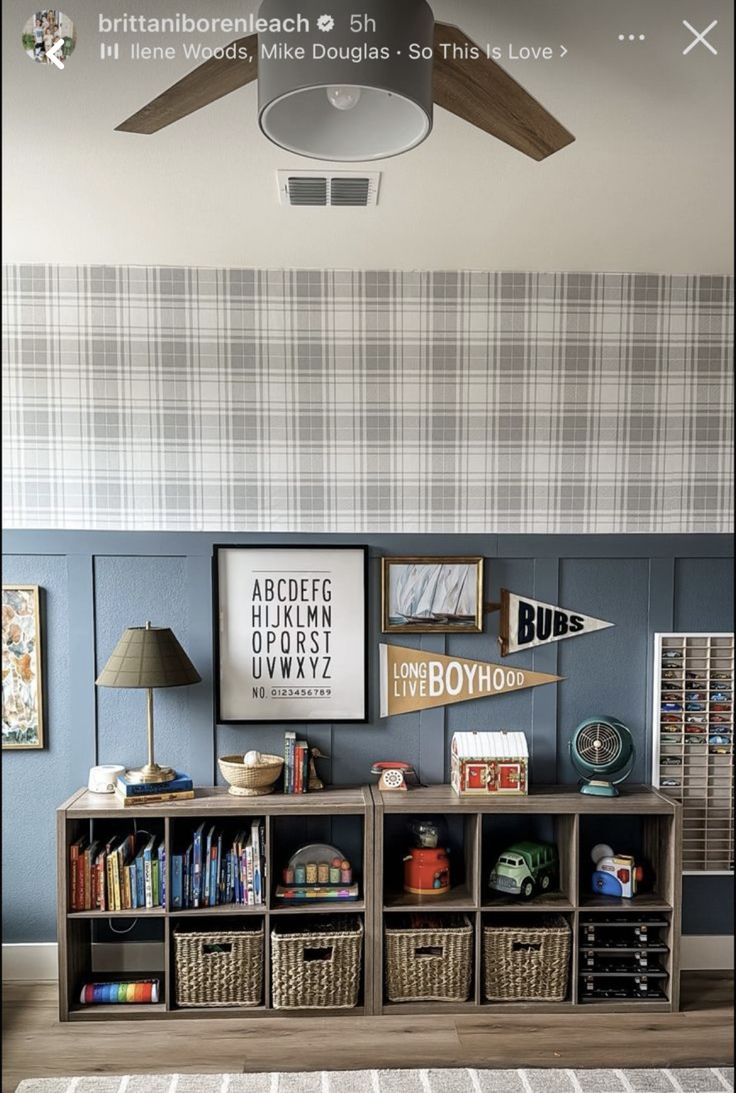 a living room with blue walls and pictures on the wall, bookshelves and baskets