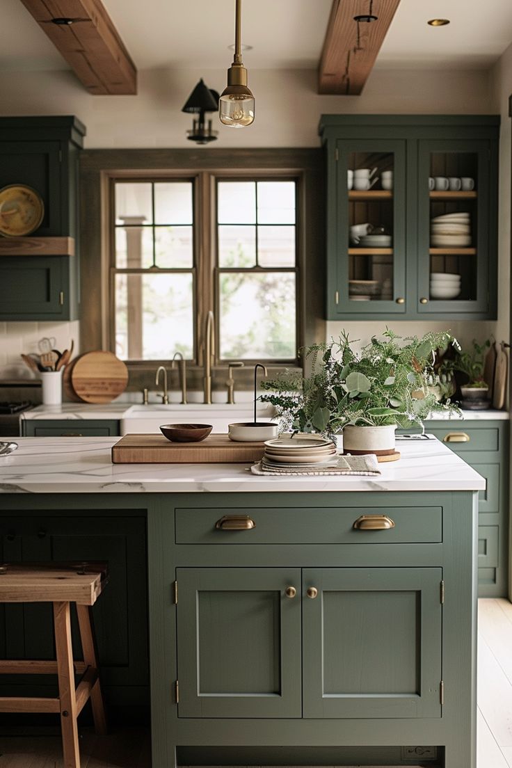 a kitchen with green cabinets and white marble counter tops, wooden flooring and hanging lights