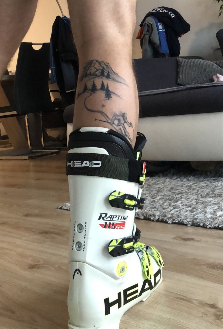 a person with tattoos on their legs and skis