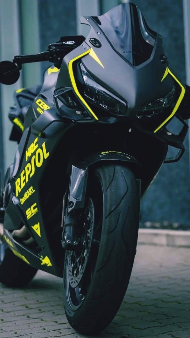 a black and yellow motorcycle parked in front of a building