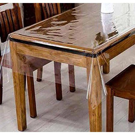 a glass table with wooden chairs and a vase sitting on top of the table in front of it