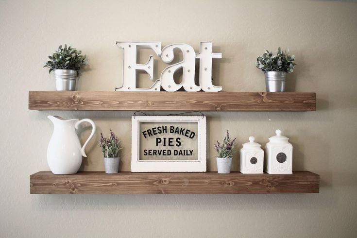 two wooden shelves with some plants and other items on top of them, one shelf has a sign that says eat