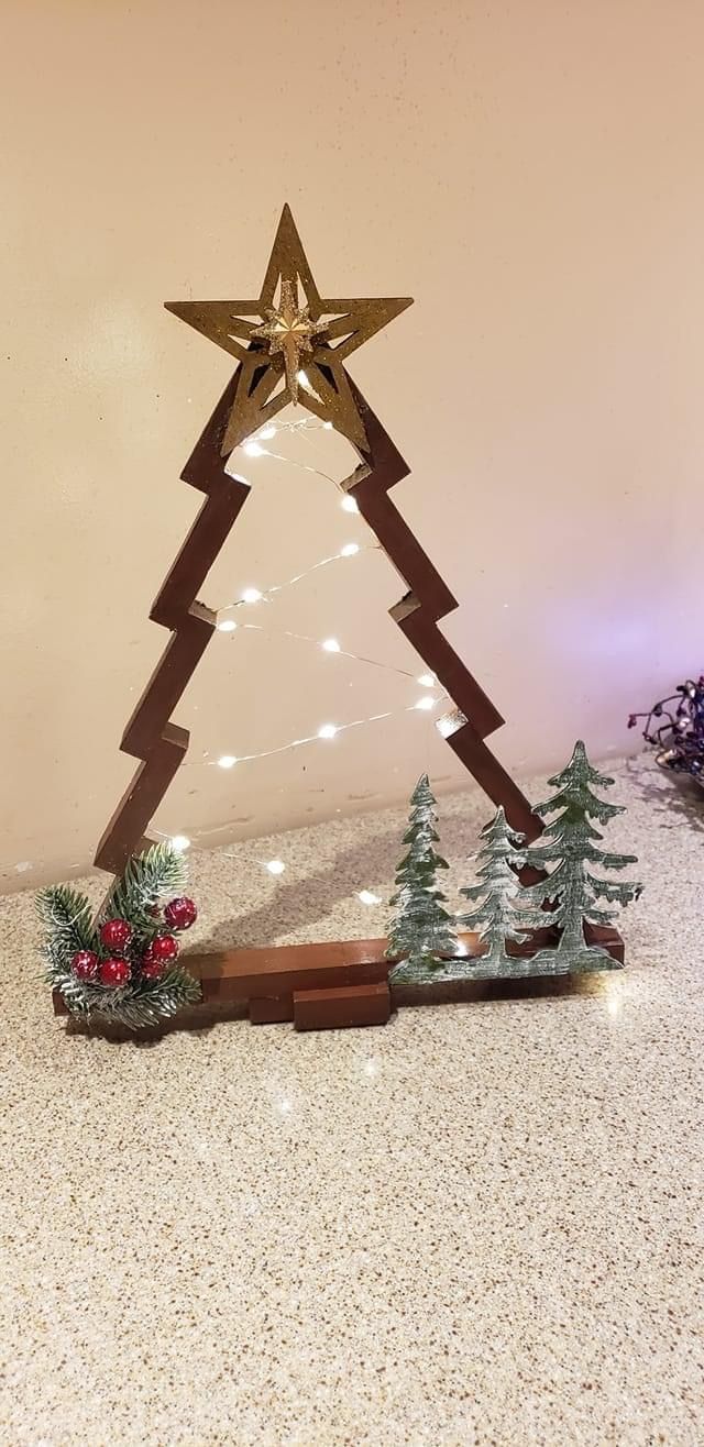 a christmas tree made out of wood with lights around it and decorations on the bottom