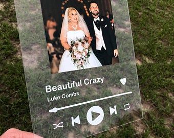 a person holding up a sign with an image of a bride and groom