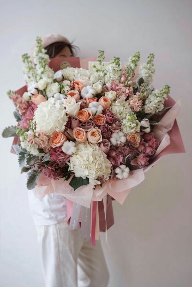 a woman holding a large bouquet of flowers