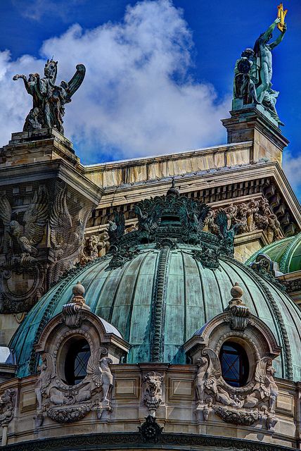 the top of a building with statues on it