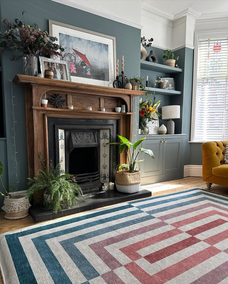 a living room filled with furniture and a fire place next to a window covered in plants