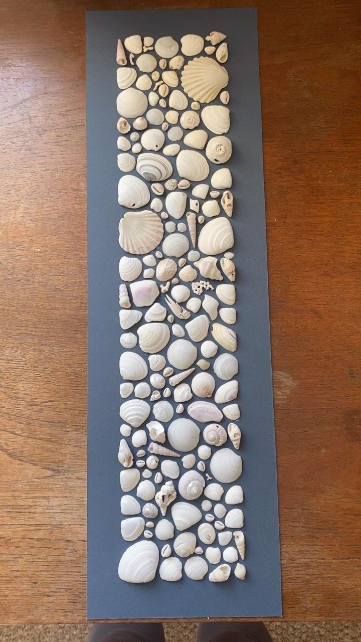 a person standing next to a wall made out of rocks and pebbles on a wooden floor