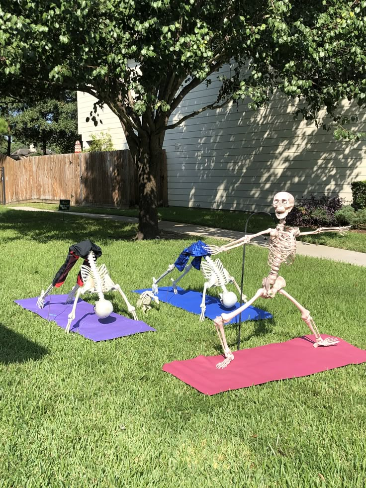 two skeleton figurines practicing yoga in the yard