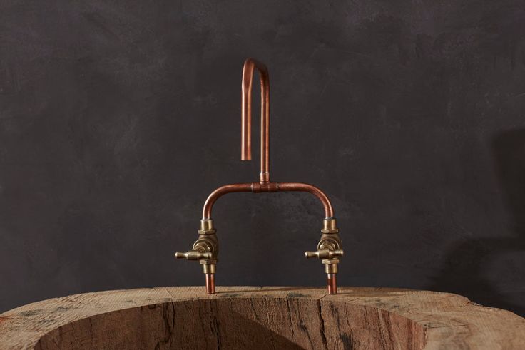 an old fashioned faucet on top of a wooden barrel