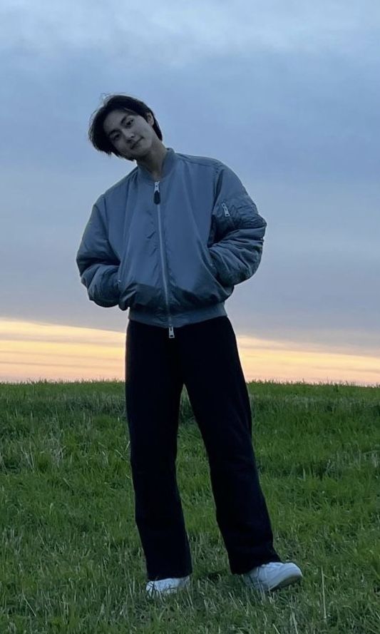 a man standing on top of a lush green field