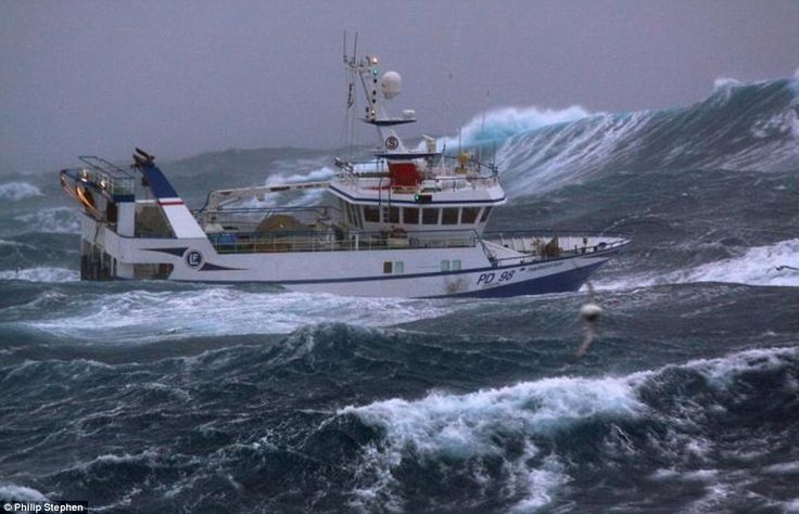 a large boat in the middle of rough ocean waves