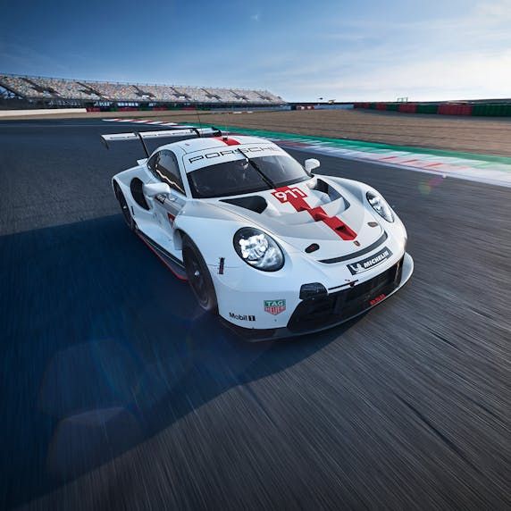 a white sports car driving on a race track