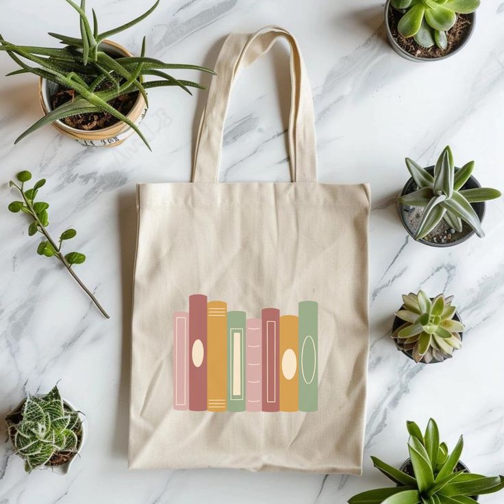 a tote bag sitting on top of a table next to potted plants and succulents