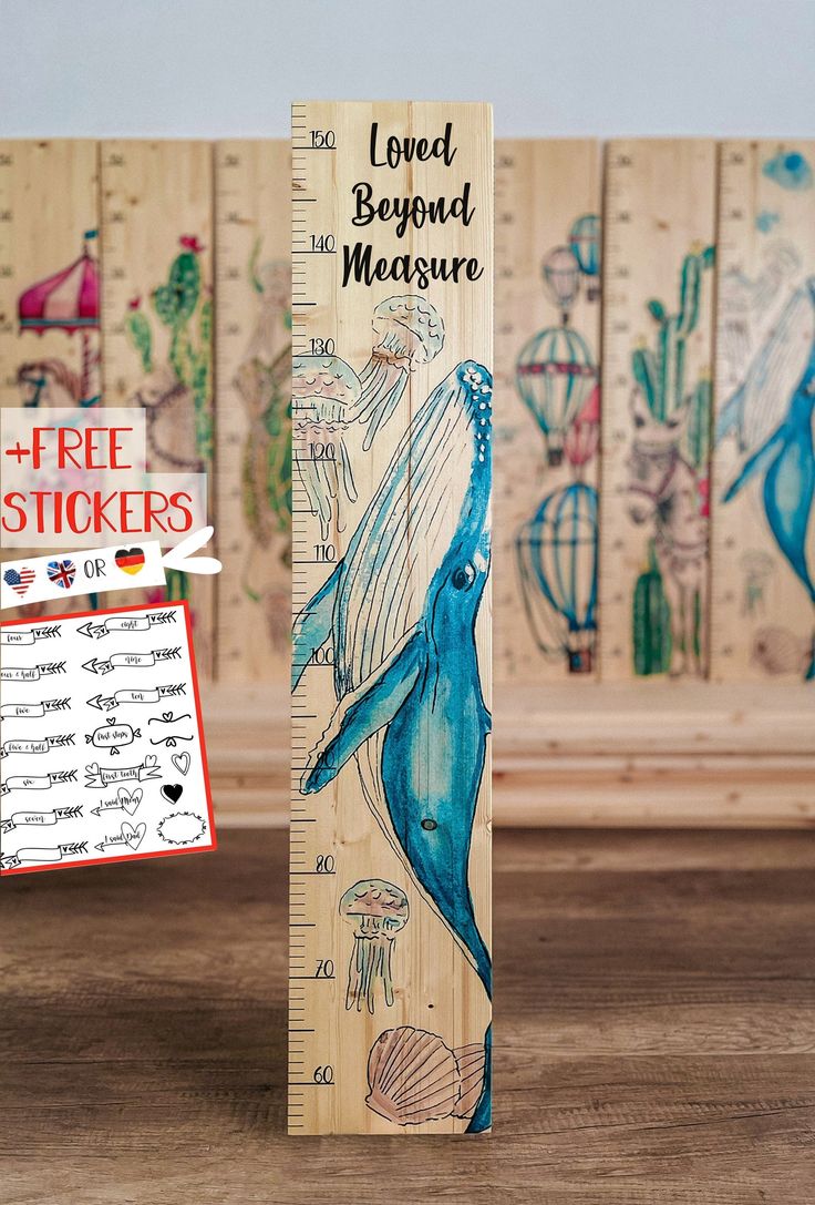 a wooden ruler with an image of a blue whale on it and the words loved beyond measure