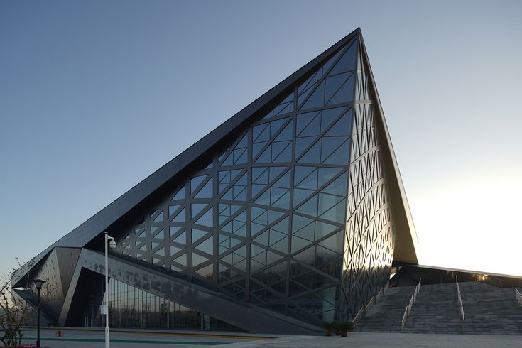 a large triangular shaped building sitting on the side of a road