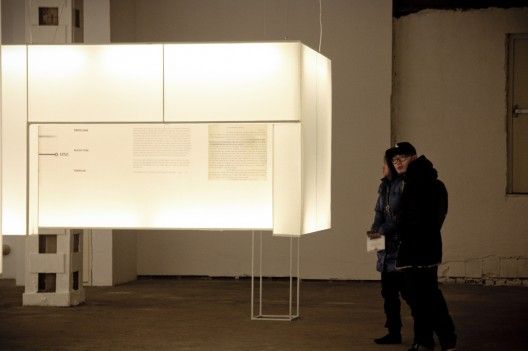 a man standing in front of a large white object with strings hanging from it's sides