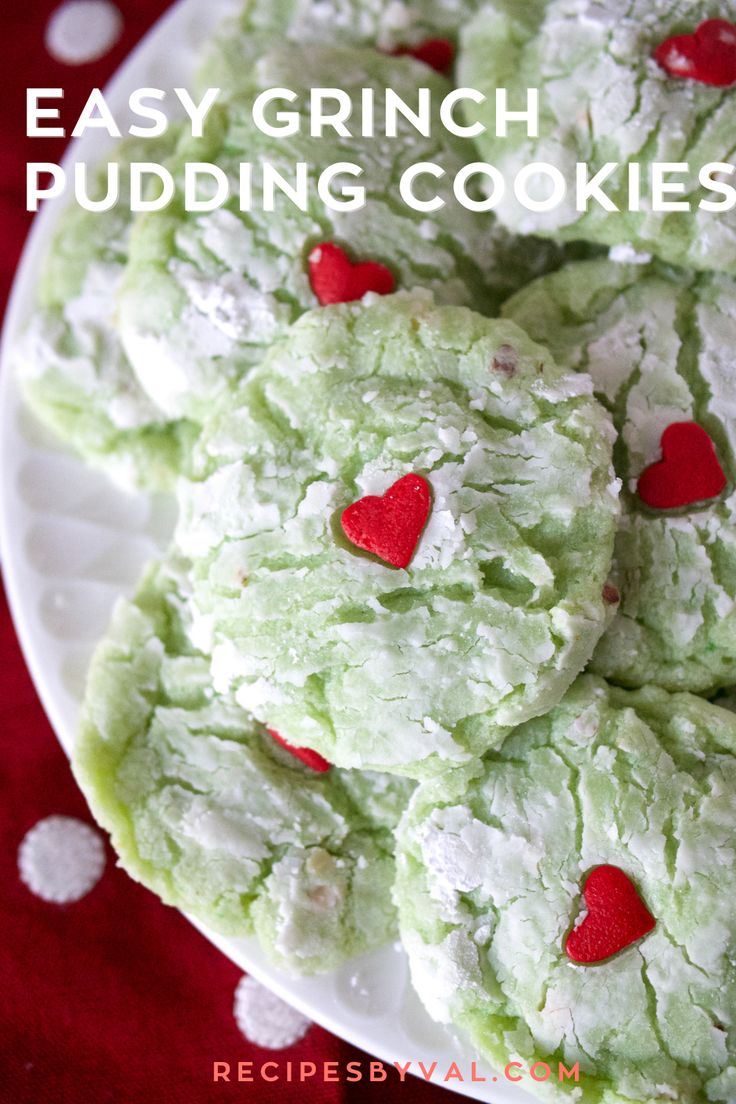 green cookies with red hearts are on a white plate, ready to be eaten for valentine's day