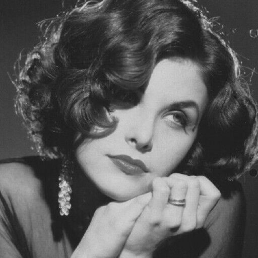 an old black and white photo of a woman with her hand on her chin looking at the camera