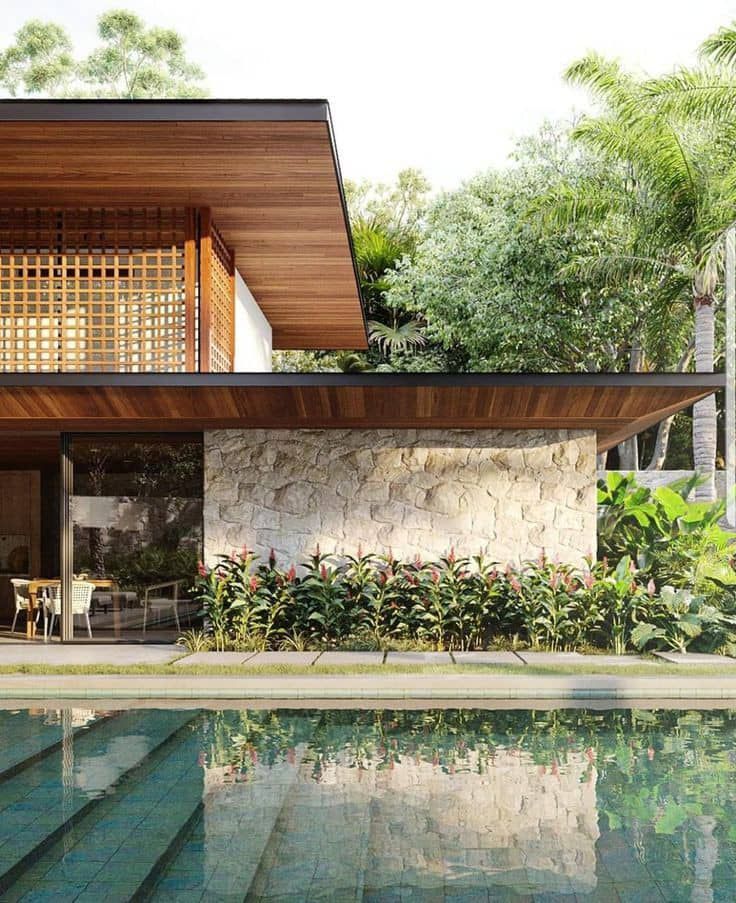 a house with a pool in front of it surrounded by palm trees and greenery