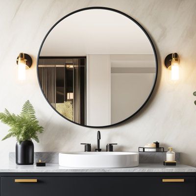 a bathroom vanity with a round mirror above it and a potted plant on the counter