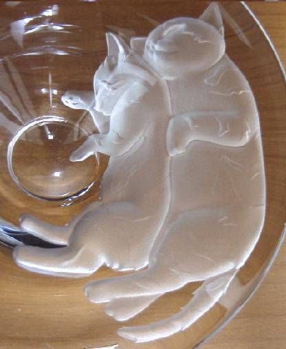 a glass bowl that has some white cats in it