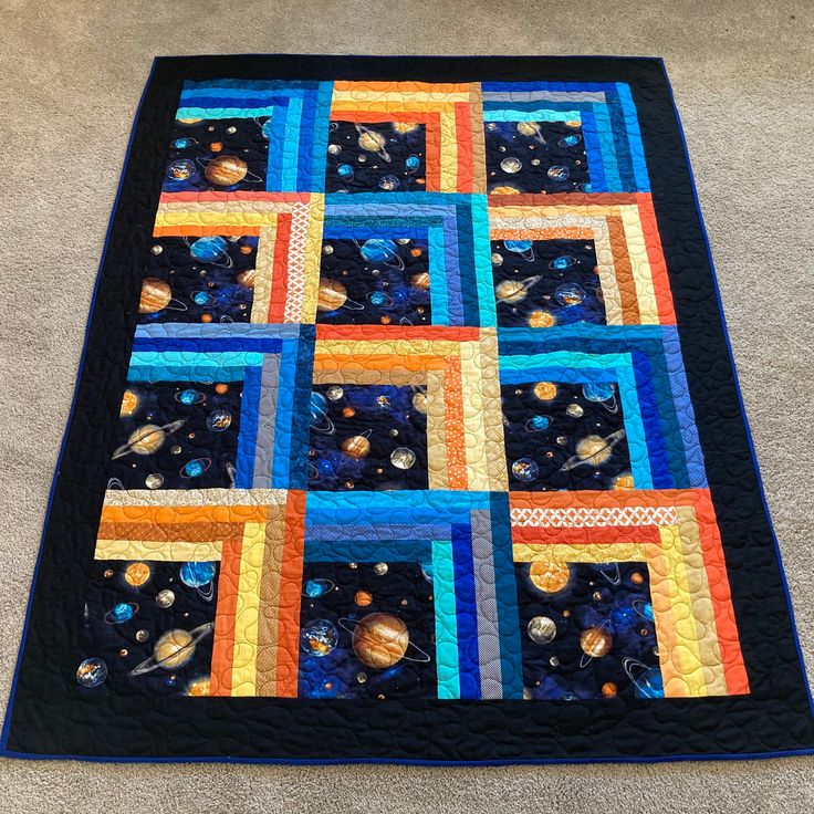 a quilted space themed table topper on the floor