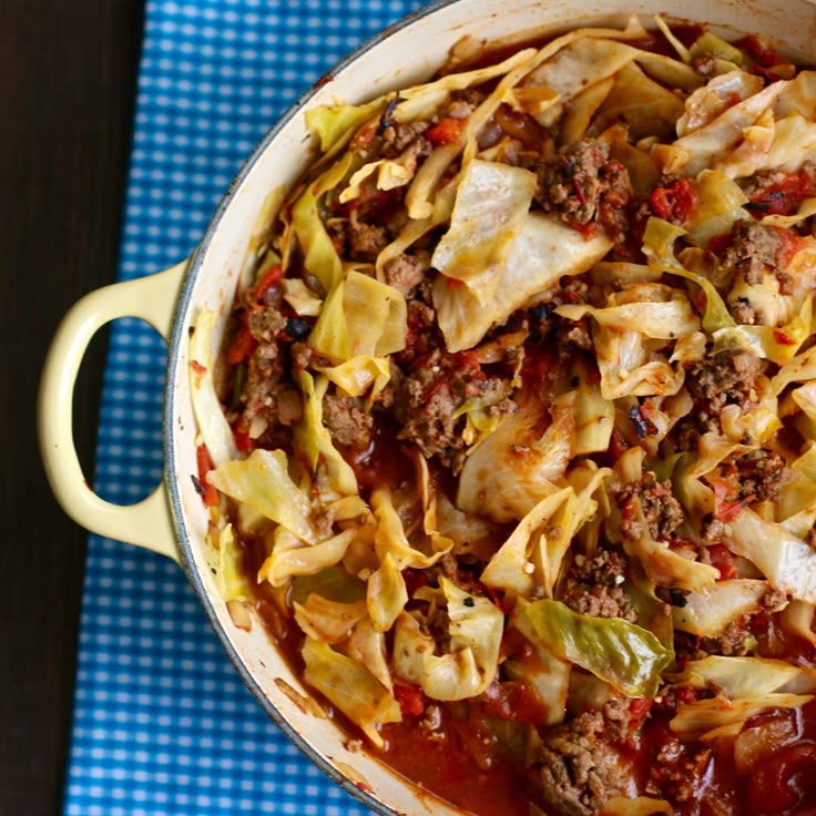 a big pot filled with some tasty looking food on top of a blue and white checkered table cloth