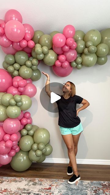 a woman standing in front of a balloon wall