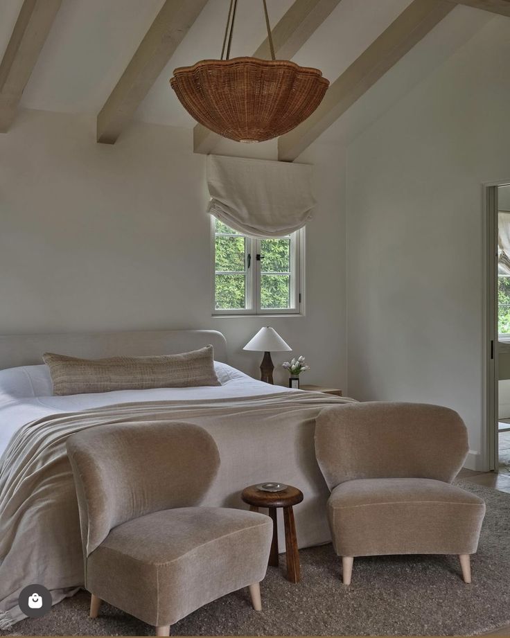 a bedroom with a bed, two chairs and a basket hanging over the headboard